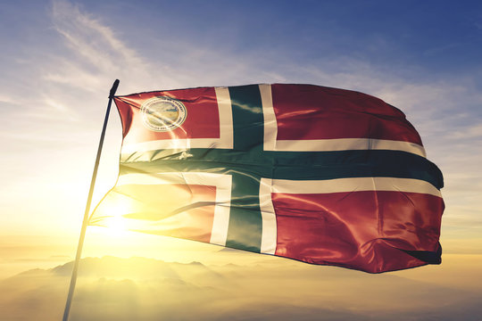 Amambay department of Paraguay flag waving on the top sunrise mist fog