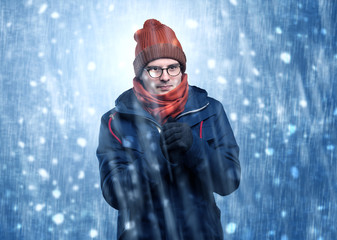 Handsome young boy shivering and trembling at snowstorm concept
