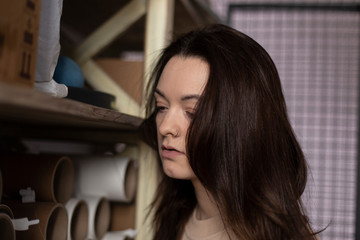 girl in pink beage casual dress Smiling and checking stock are available. For delivery to customers. In the office filled with product boxes. And packing equipment