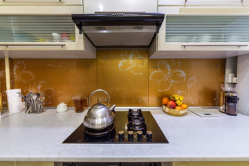 Shiny stainless tea kettle teapot with boiling water on burning