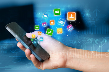 Hand using phone with bouncing colorful application and global reports and graphs concept
