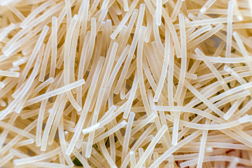 Close-up of raw dry uncooked pasta, abstract background. Italian traditional cuisine popular ingredient, nutrition, healthy tasty diet concept.