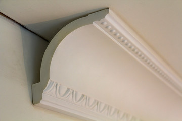 Close-up detail of decoration white molding connected with glue adhesive to wall and ceiling in interior room renovation and reconstruction. © bilanol