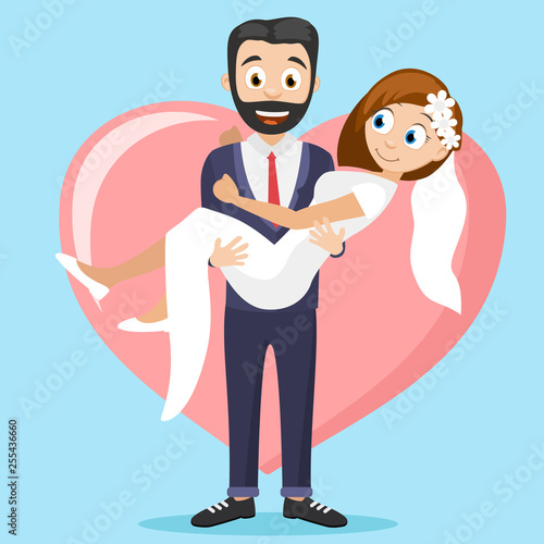 Groom holds the bride in his arms against the background of a big heart.