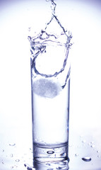 Ecology concept. Splash from ice thrown into a glass of clean water