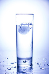 Ecology concept. Splash from ice thrown into a glass of clean water