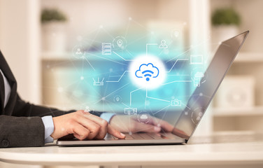 Business woman in homey environment using laptop with  online storage and cloud technology concept
