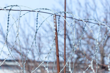 Fence with barbed wire against the sky