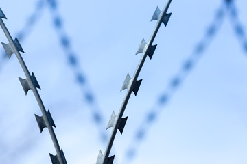Fence with barbed wire against the sky