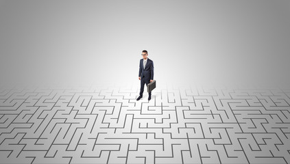 Elegant businessman looking for a solution in a middle of a maze

