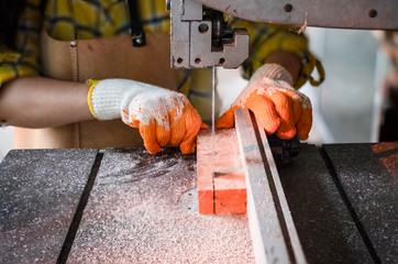 Women standing is craft working cut wood at a work bench with band saws power tools at carpenter machine in the workshop, Worker sawing boards from with sawmill wood processing a family business