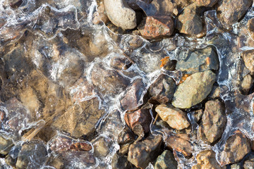 Obraz premium Ice crystals on a stony wet ground on a clear morning