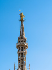 Fototapeta na wymiar Madonnina golden statue on top of Milan Cathedral