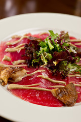 steak carpaccio with mushrooms and arugula salad