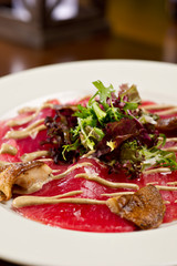 steak carpaccio with mushrooms and arugula salad