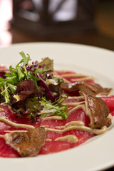 steak carpaccio with mushrooms and arugula salad