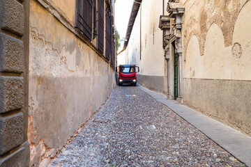 Fototapeta na wymiar lorry truck on narrow medieval street in Italy