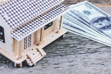 money and a house on a wooden table