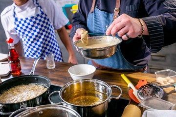 Chef puts the slices of fish with batter in the pan with butter. Master class in the kitchen. The process of cooking. Step by step. Tutorial. Close-up