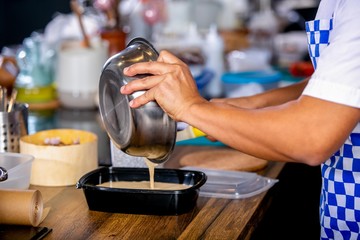 The cook pours the batter out of the bowl into a baking dish. Master class in the kitchen. The process of cooking. Step by step. Tutorial. Close-up