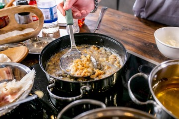 Chef mixes pieces of fish, frying them in a pan. Master class in the kitchen. The process of cooking. Step by step. Tutorial. Close-up