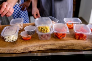 The cook lays out the jars with blanks of products for cooking. Master class in the kitchen. The process of cooking. Step by step. Tutorial. Close-up
