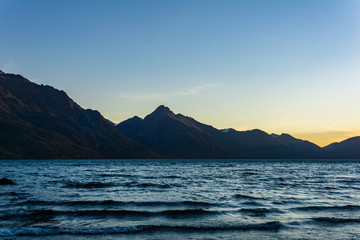 peaceful landscape during sunset with calm sky above the lake and mountain range