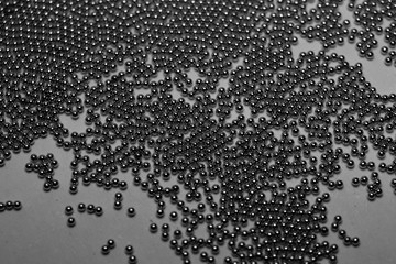Close-up of industrial electronics assembly manufacturing materials RoHS 0.6mm round BGA soldering balls in partial focus randomly scattered on a gray background
