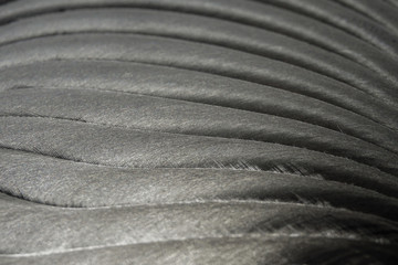 Close-up of industrial realistic gray color stainless steel flat part in partial focus after industrial CNC routing processing with high contrast abstract light reflections