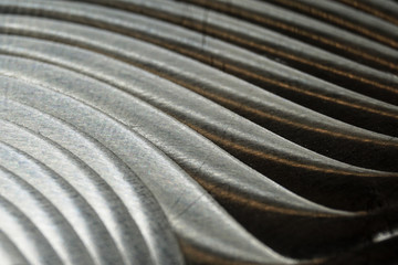 Close-up of industrial realistic gray color stainless steel flat part in partial focus after industrial CNC routing processing with high contrast abstract light reflections