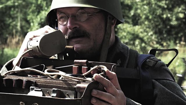 Soldier is talking with radio while other soldiers passing