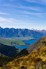 peaceful landscape during sunny day above the lake, valley and mountain range, mountain peaks partially covered with snow