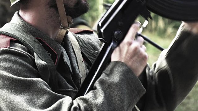 Soldier makes his rifle ready while other soldiers passing