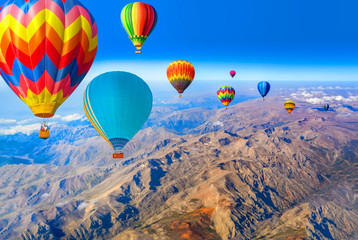 Obraz premium Hot air balloon flying over amazing mountains