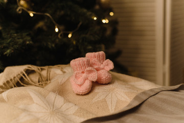 baby booties on new year background. Christmas gift on the background of the Christmas tree. waiting for baby