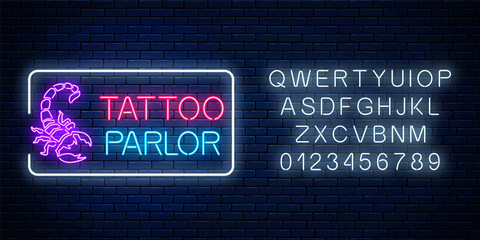 Fototapeta na wymiar Tattoo parlor glowing neon signboard with scorpio emblem and alphabet. Tattoo salon sign in rectangle frame.