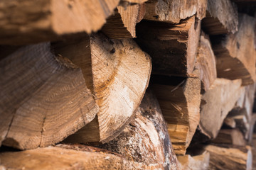 Cracked wood in the sun. Woodpile (tree stack) on rusty background. Stacks of firewood. Firewood for the winter.