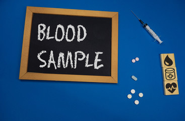 wooden tablet on blue medical table with the word blood sample