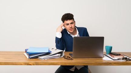 Business man in a office with problems making suicide gesture