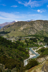 idillic landscape with moutnain range, river and small town in the valley