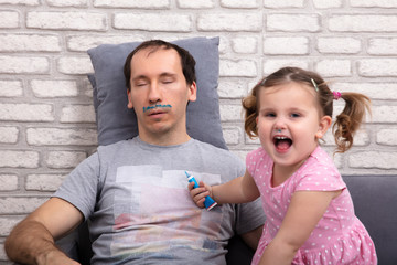 Child Painting Father's Face While He Is Sleeping