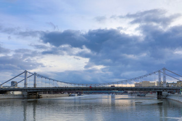 Krymsky Bridge or Crimean Bridge  across the Moskva river in Moscow in the rays of setting sun in the evening blue hour 