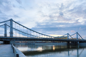 Krymsky Bridge or Crimean Bridge  across the Moskva river in Moscow in the rays of setting sun in the evening blue hour 