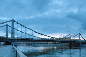 Fototapeta premium Krymsky Bridge or Crimean Bridge across the Moskva river in Moscow in the rays of setting sun in the evening blue hour 