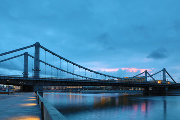Krymsky Bridge or Crimean Bridge  across the Moskva river in Moscow in the rays of setting sun in the evening blue hour 