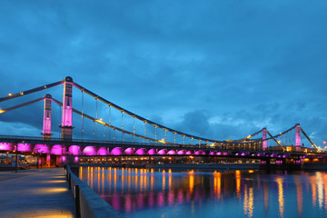Krymsky Bridge or Crimean Bridge  across the Moskva river in Moscow in the rays of setting sun in the evening blue hour with illumination