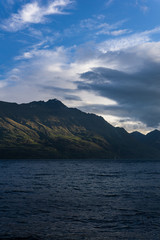 peaceful landscape during sunset with dramatic sky above the lake and mountain range