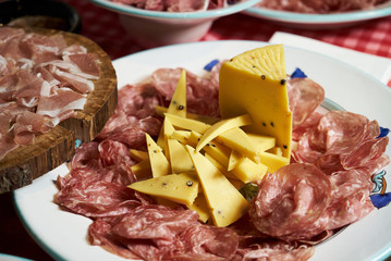 Food tray with sliced ham meat and cheese top view, close-up