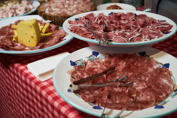 Food tray with sliced ham meat and cheese top view, close-up