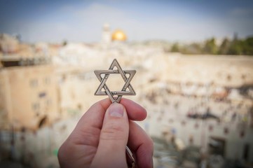 JERUSALEM, ISRAEL. February 15, 2019. Hand holding a Star of David, a Jewish religious symbol...